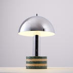 Clérachic lamp photographed at an angle with its dome lit from within, a warm glow visible along the inner rim.
