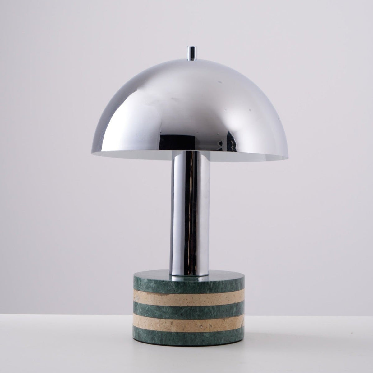 Clérachic lamp at a slight angle against the grey backdrop, its dome catching a soft highlight along one edge.