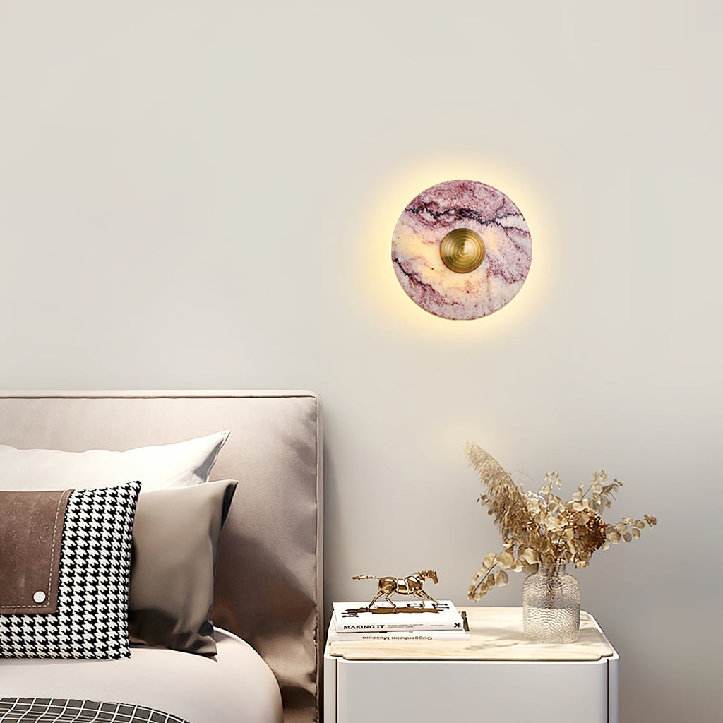 Clérachic's wall light glows above a beige headboard with a houndstooth cushion, next to a nightstand with books and a vase.