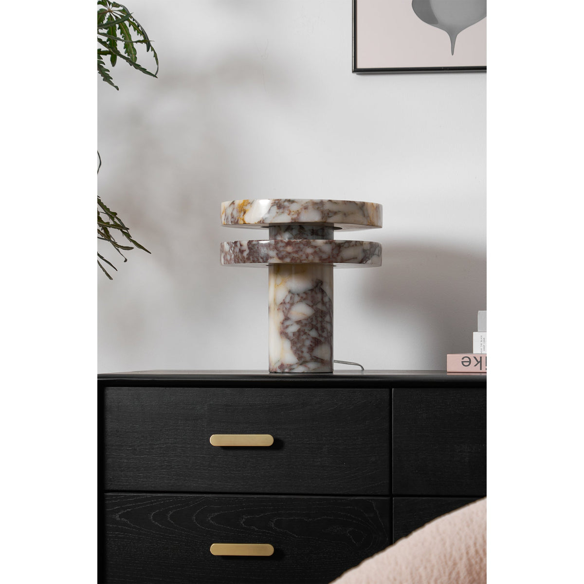 Clérachic lamp unlit on the dresser, a dark branch overhead and the drawer pulls lined up below its marble base.