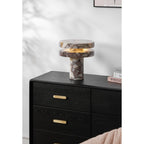 Clérachic lamp lit on the full dresser, a folded blush throw draped over furniture in the foreground corner.