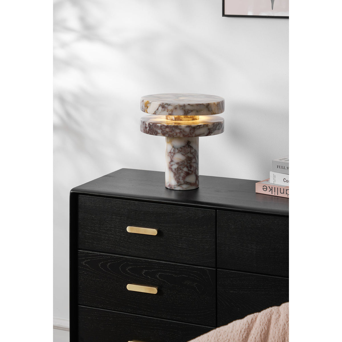 Clérachic lamp lit on the full dresser, a folded blush throw draped over furniture in the foreground corner.