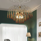 This Clérachic chandelier hangs in a room with a dark green wall, sheer curtain and a floor lamp nearby.
