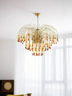 This Clérachic pendant's caramel crystal drops hang near a sheer curtain, dark wood shelving visible below.