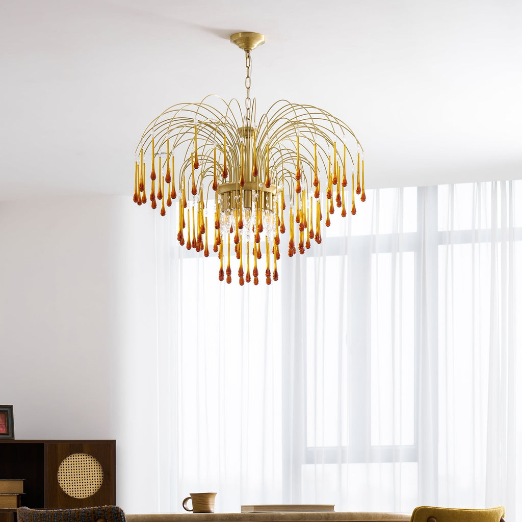 Caramel crystal drops on this Clérachic pendant catch the light beside a mustard-yellow chair and dark wood shelving.