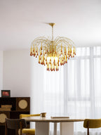 This Clérachic pendant's caramel crystal drops hang above a mustard-yellow chair, sheer curtains lit brightly behind it.