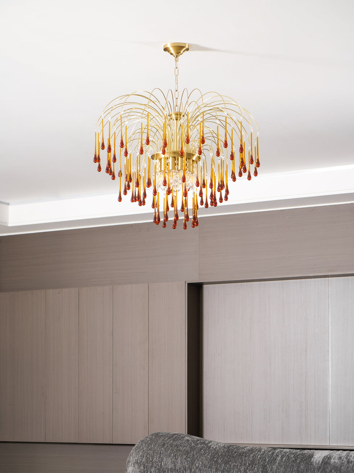 This Clérachic pendant hangs above a grey sofa and pale wood-panelled wardrobe with sliding doors.