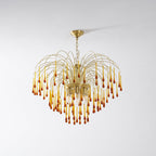 The fullest tiers of caramel crystal drops on this Clérachic pendant are shown lit on a plain light background.