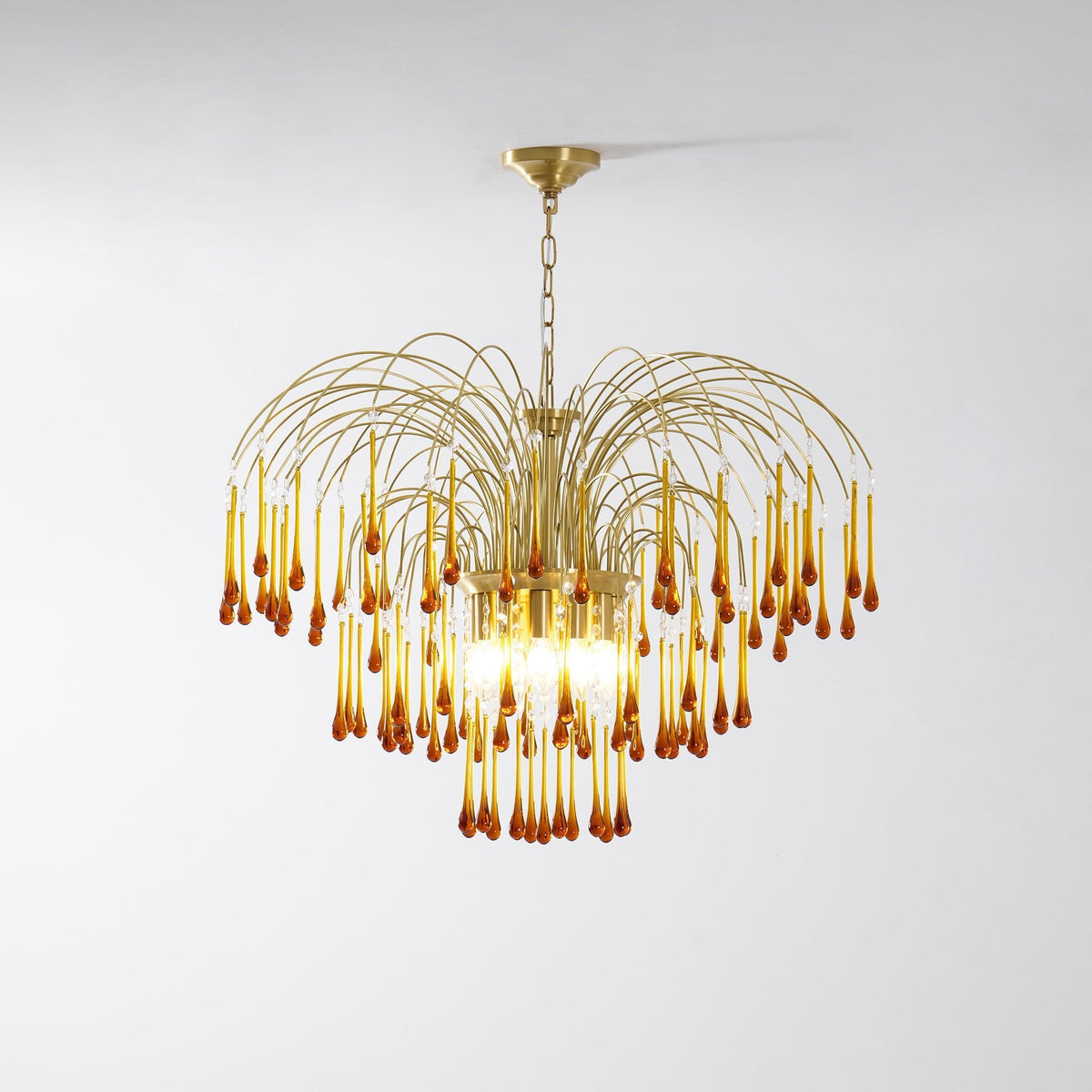 A wide fountain shape of caramel crystal drops spreads from this Clérachic pendant, lit on a plain background.