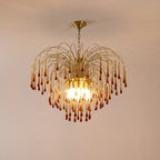 Warm pink-toned light surrounds this Clérachic pendant, its caramel crystal drops lit against a soft peach backdrop.