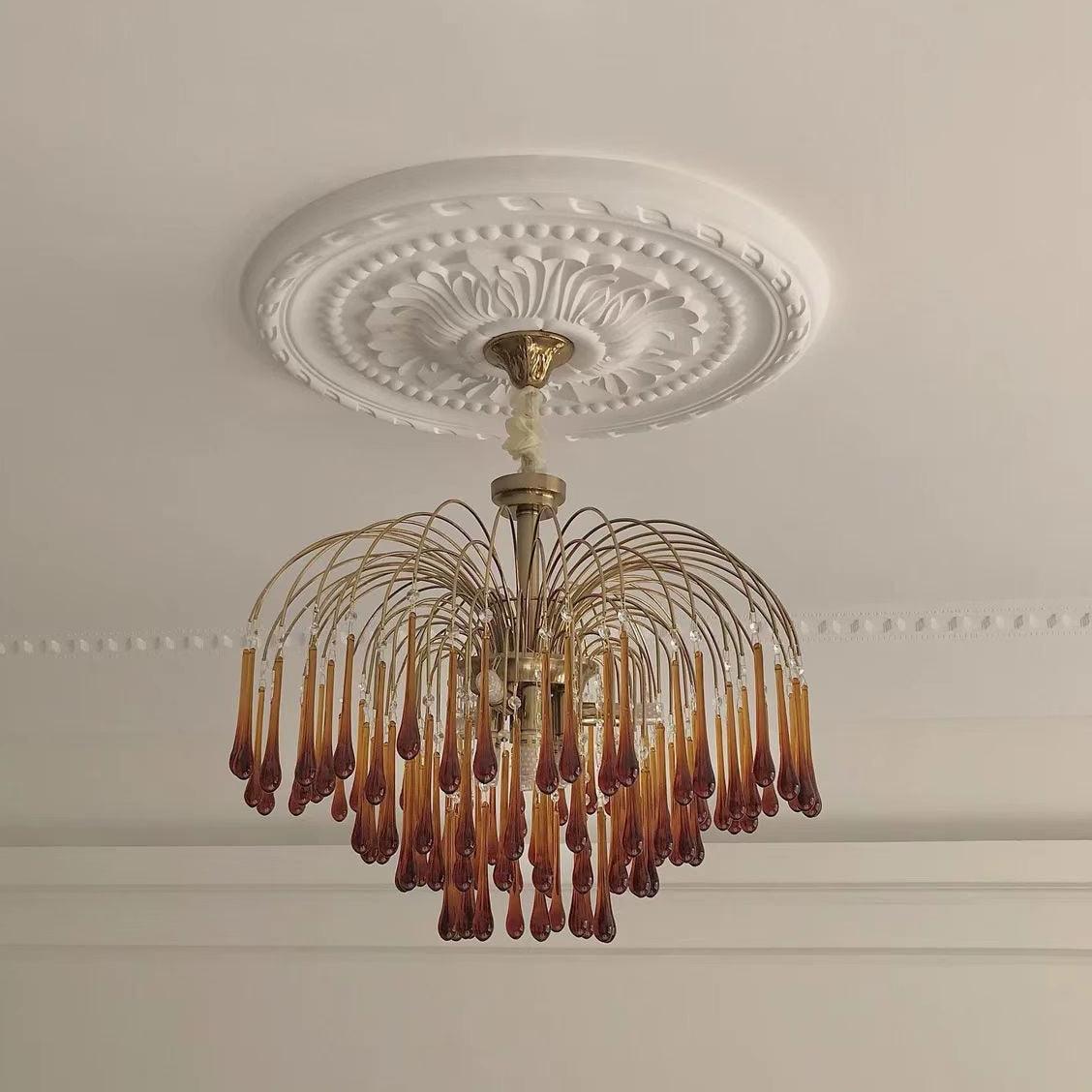 This Clérachic pendant hangs from an ornate ceiling medallion, its caramel crystal drops close beneath the moulded rose.