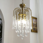 This Clérachic pendant hangs near an arched doorway and framed picture, its clear crystal drops lit warm.