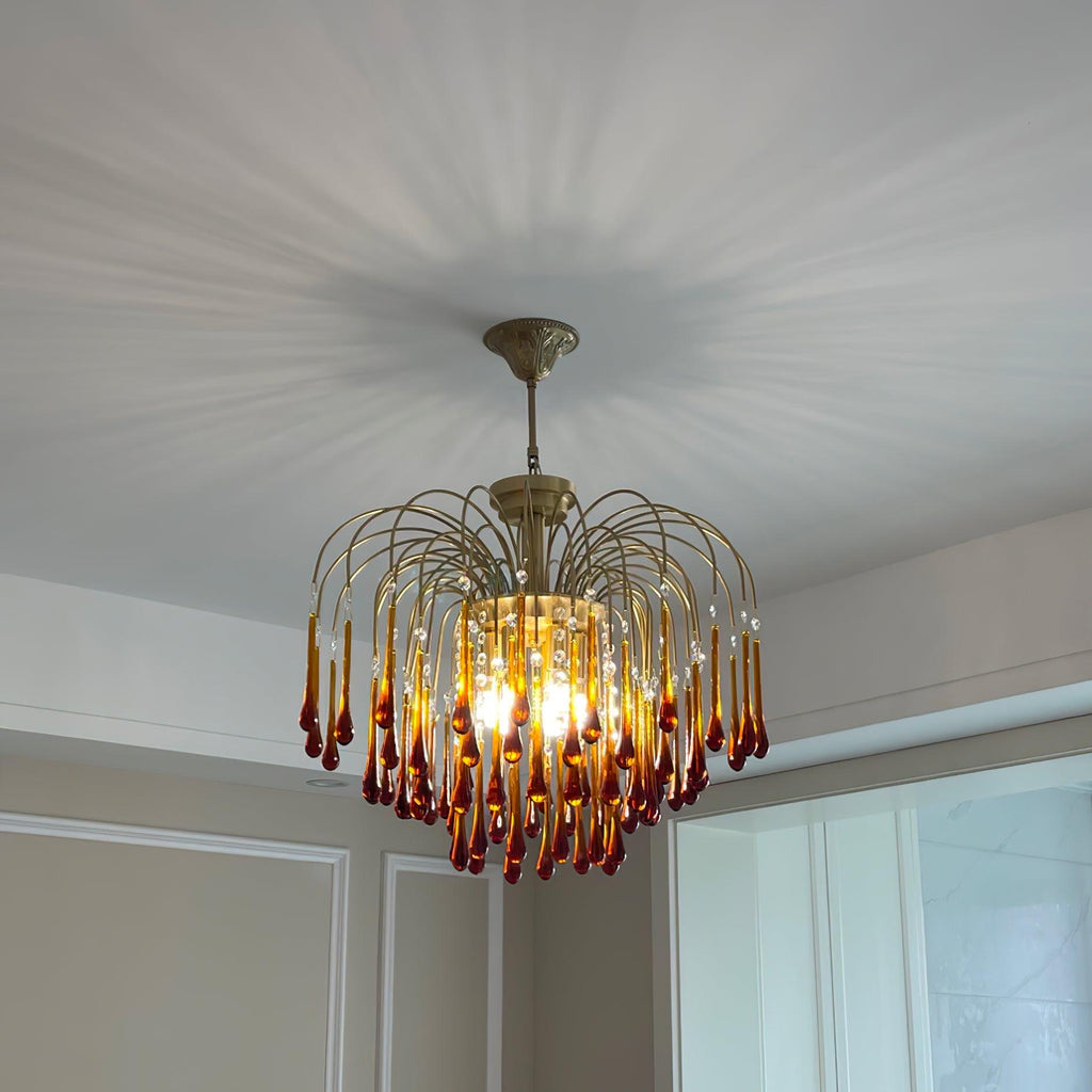 Dramatic light rays radiate across the ceiling above this Clérachic pendant, its caramel crystal drops glowing warm.