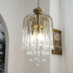 This Clérachic pendant's clear crystal drops hang beside a gilt-framed picture near an arched doorway.