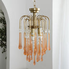 Blush-caramel crystal drops on this Clérachic pendant hang beside a leafy plant on a plain white background.