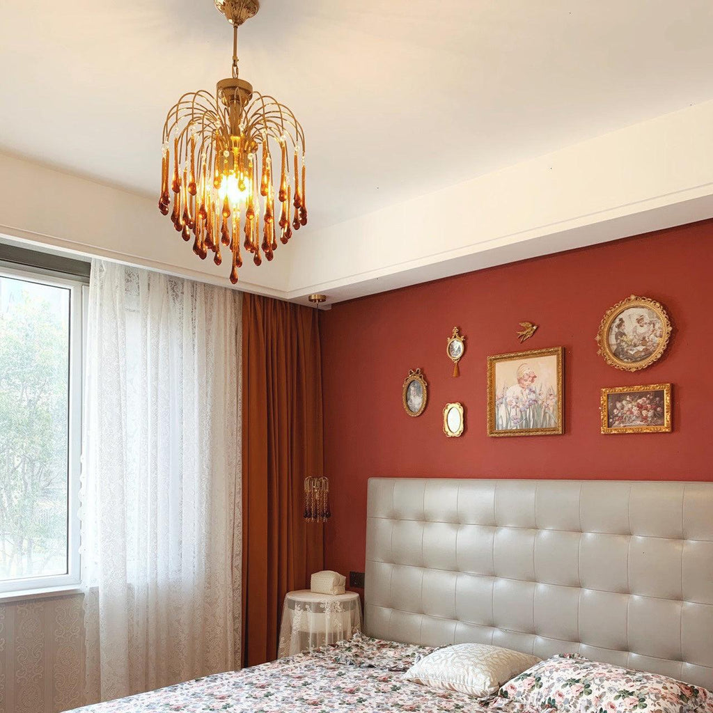 This Clérachic pendant hangs in a bedroom with a terracotta wall, tufted headboard and decorative wall plates below.