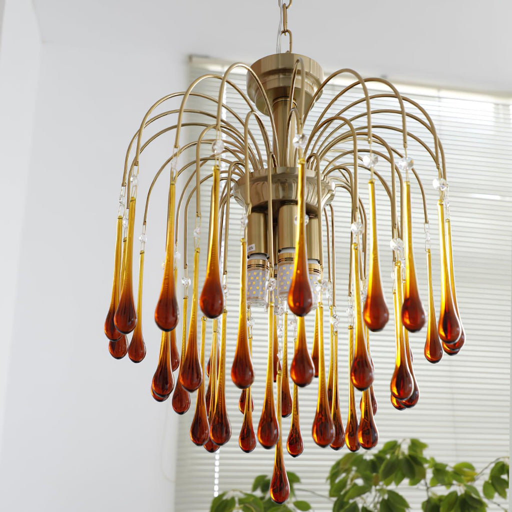 This Clérachic chandelier's caramel and clear crystal drops cascade past white venetian blinds in the background.