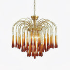 Caramel crystal drops fan out beneath brass arms on this Clérachic chandelier, shown isolated on a plain background.