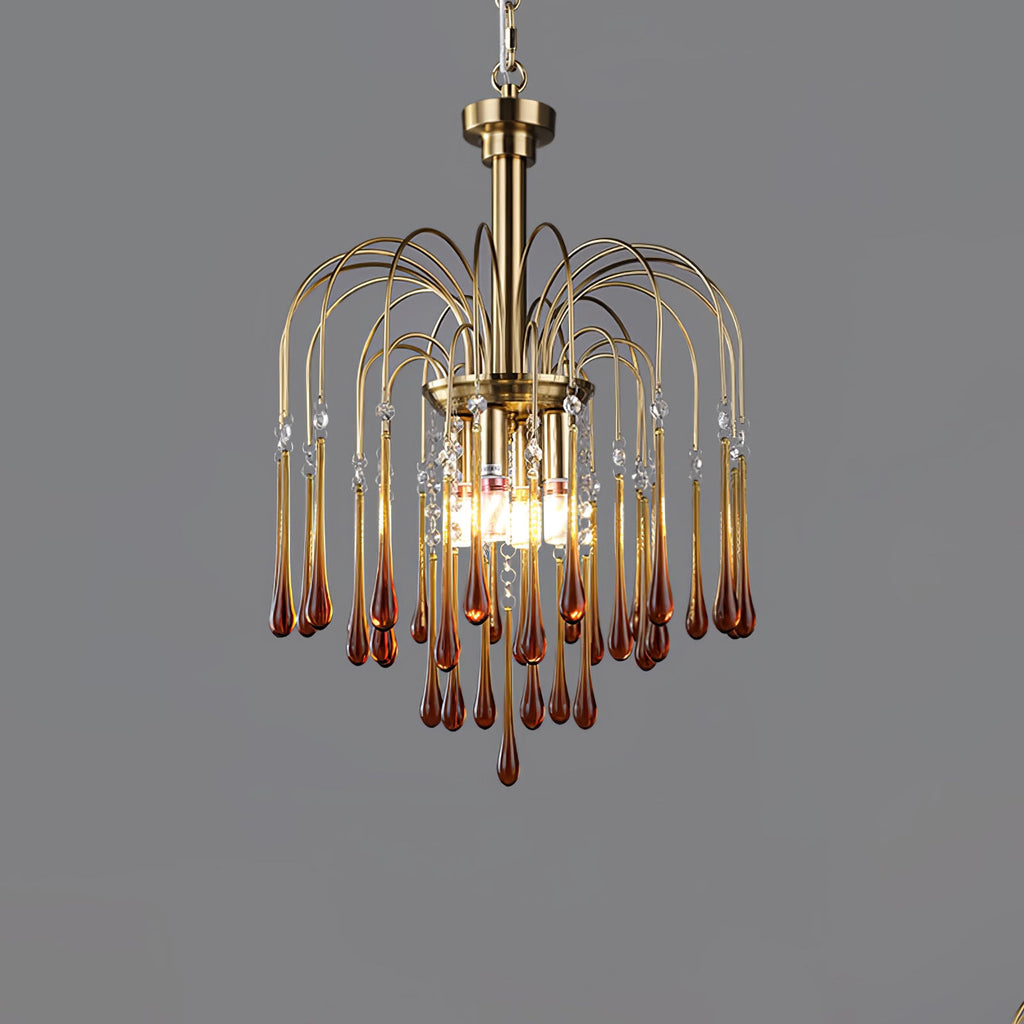 This Clérachic pendant's caramel crystal drops are lit against a plain dark grey background, brass arms fanning outward.