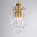 This Clérachic pendant's clear crystal drops are lit against a dark grey background, tiers layered beneath the brass arms.