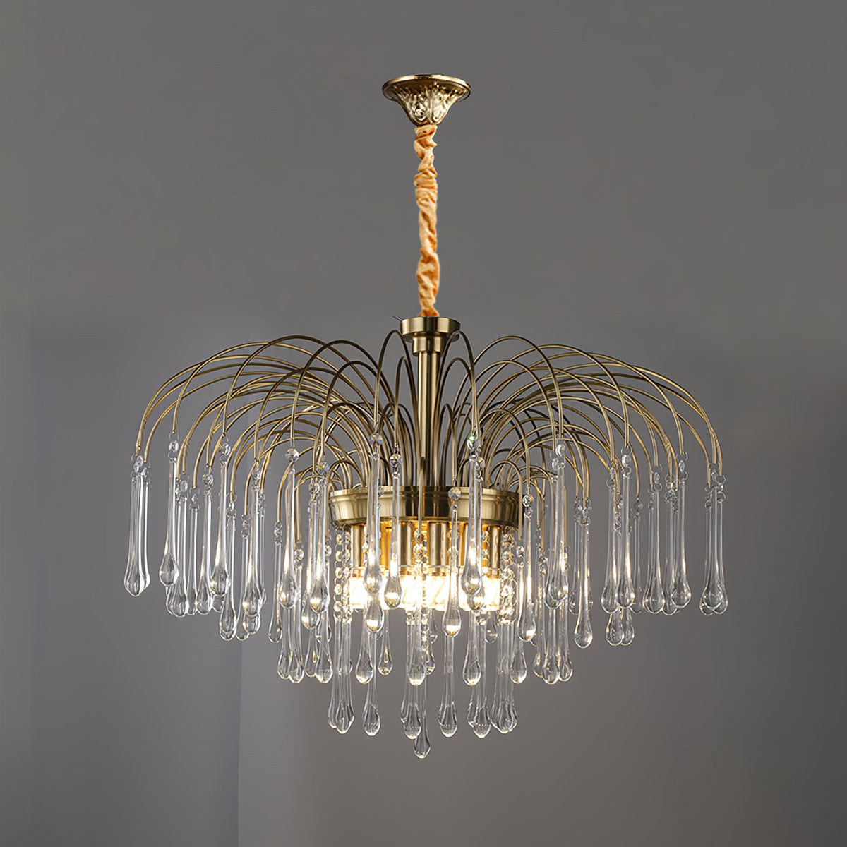 A twisted cord replaces the chain on this Clérachic chandelier, its clear crystal drops lit against a dark grey backdrop.