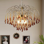 This Clérachic chandelier's mix of caramel and clear crystal drops hangs before a wall of framed vintage portraits.