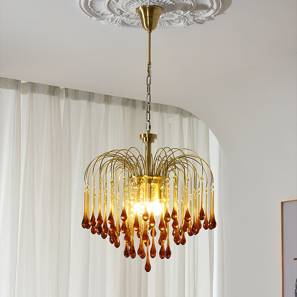 This Clérachic pendant hangs beside a sheer curtain, its caramel crystal drops catching light beneath an ornate ceiling medallion.