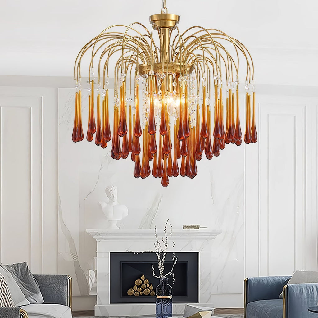 Caramel and clear crystal drops on this Clérachic chandelier hang above a white mantelpiece with a vase of branches nearby.