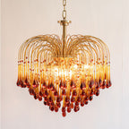 A larger tiered version of this Clérachic chandelier, its caramel crystal drops darkening toward the tips, shown lit on a plain background.