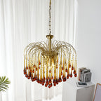 This Clérachic pendant's caramel crystal drops hang near a sheer curtain, with a small plant leaf and stacked books below.
