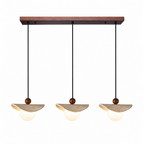Three travertine sail Clérachic pendants hang in a row from one rectangular walnut canopy, product shot.