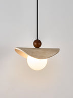This Clérachic pendant's travertine sail and walnut bead are shown against a soft white backdrop.