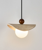 Close product shot of this Clérachic pendant's travertine sail, walnut bead, and glowing opal globe.