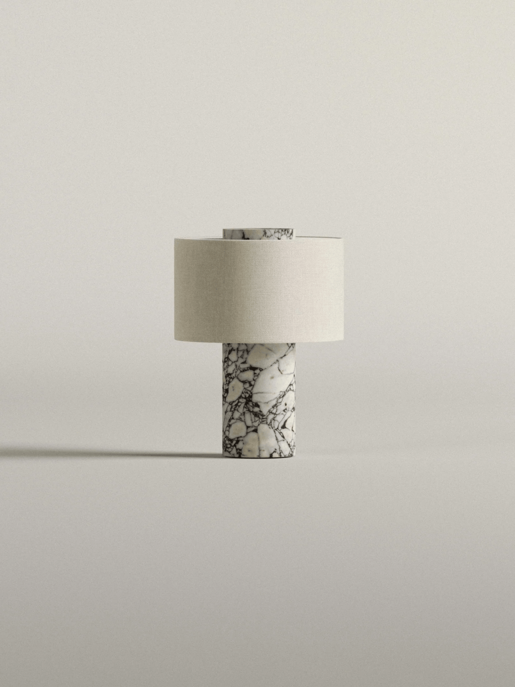 This Clérachic cordless table lamp stands small and isolated, its white-veined marble base and cream shade lit softly.