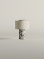 This Clérachic cordless table lamp stands small and isolated, its white-veined marble base and cream shade lit softly.