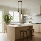 Two black-finish Clérachic pendant lights hang over a white kitchen island in a light oak kitchen with a potted plant nearby.