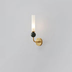 Angled against a plain grey background, a Clérachic brass-arm wall sconce shows off its green marble orb up close.