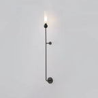 A tall Clérachic black vertical wall light shown full length against a plain grey background, lit at the top.