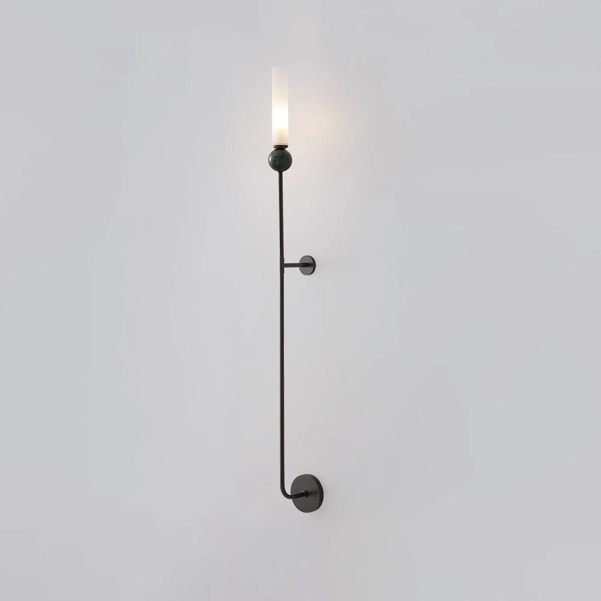 A tall Clérachic black vertical wall light shown full length against a plain grey background, lit at the top.