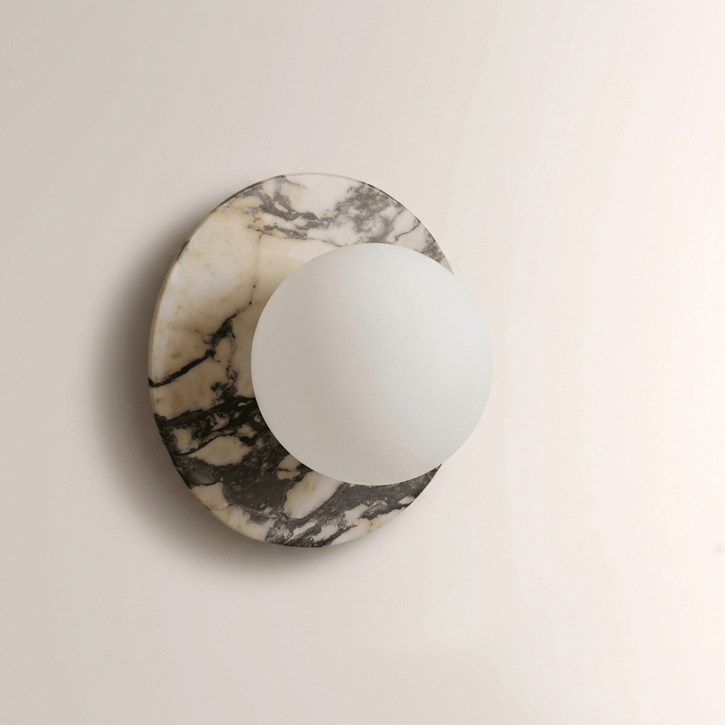 A second close-up of the grey-veined marble Clérachic wall sconce, showing the opal globe seated flush against the disc's edge.