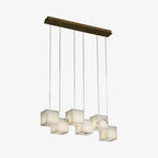 Small-scale studio view of the six-head Ivnoros chandelier, brass bar and six unlit alabaster cubes.
