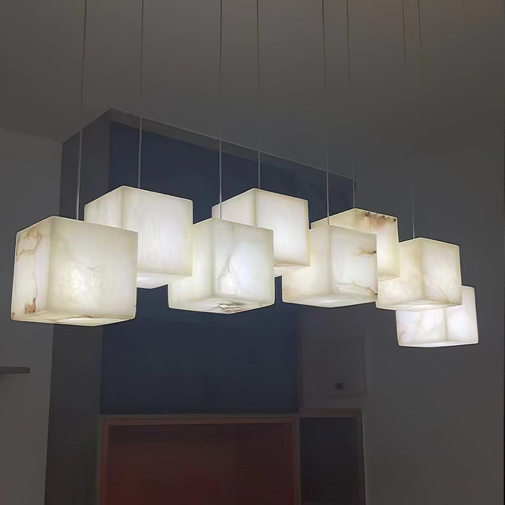Close view from below of the lit alabaster cubes, warm light bringing out the veining in the stone.