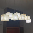 Close view from below of the lit alabaster cubes, warm light bringing out the veining in the stone.