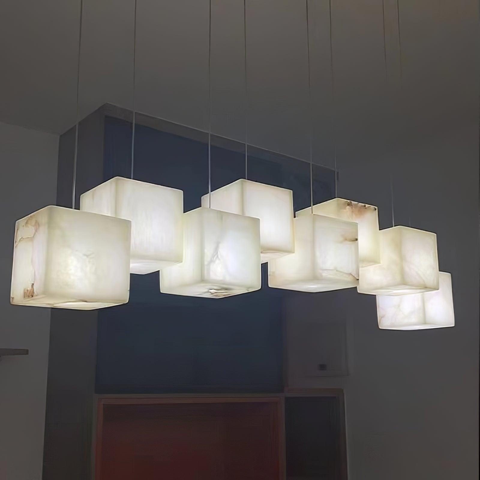 Close view from below of the lit alabaster cubes, warm light bringing out the veining in the stone.