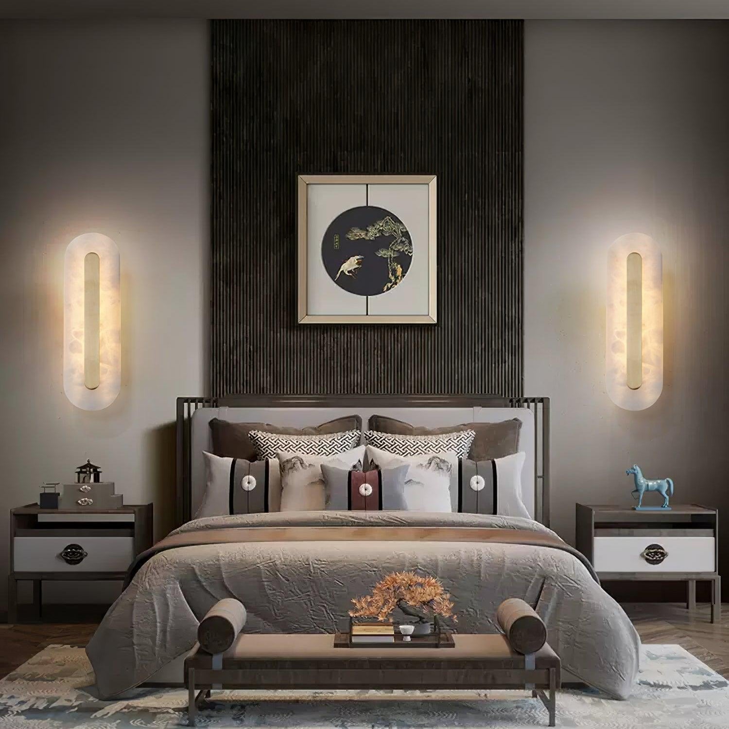 Clérachic matching Selvia wall lights lit either side of a bed, framing a dark fluted headboard panel