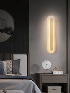 Brass and alabaster sconce illuminating a textured interior wall