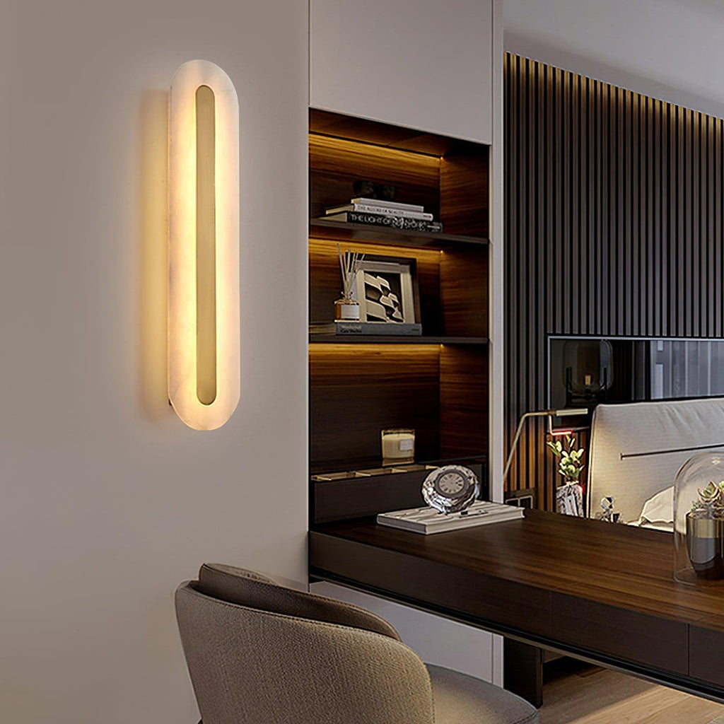 Clérachic selvia wall light seen at an angle on a white wall of a study, lit beside a walnut desk nook