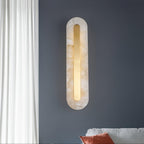 Clérachic selvia wall light on a deep blue-grey wall by a white curtain, alabaster veining clear in daylight