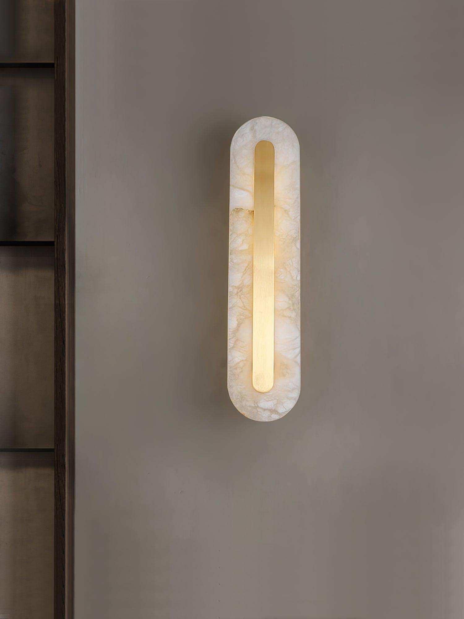 Alabaster wall light mounted vertically with a gentle warm glow