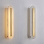 Two Clérachic Selvia wall lights side by side on a white plaster wall, one lit and one switched off
